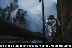 Seorang petugas pemadam kebakaran berusaha memadamkan api di sebuah pembangkit listrik yang terkena serangan drone yang dilancarkan pasukan Rusia di Kyiv, pada 19 Desember 2022. (Foto: State Emergency Service of Ukraine/via Reuters)