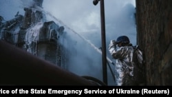 A firefighter extinguishes a fire at a critical power infrastructure, which was hit during Russia's drones attacks in Kyiv, Ukraine, Dec. 19, 2022.
