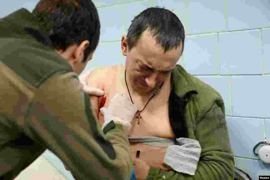 A doctor from the Ukrainian Army attends to a wounded serviceman at a field medical clinic used to stabilize patients before they are sent to a nearby hospital, in the region of Donetsk, Ukraine.