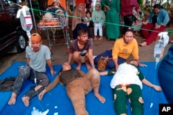People injured during an earthquake receive medical treatment in a hospital parking lot in Cianjur, West Java, Indonesia, Monday, Nov. 21, 2022. (AP Photo/Firman Taqur)