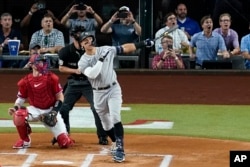 FILE - New York Yankees' Aaron Judge follows through on a solo home run, his 62nd of the season on Oct. 4, 2022. With the homer, Judge set the AL record for home runs in a season, passing Roger Maris. (AP Photo/Tony Gutierrez)