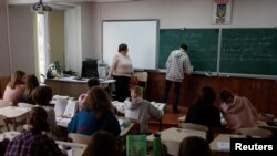 Students attend a lesson of English language in a classroom at a school amid Russia's attack on Ukraine, in Kyiv, Ukraine, Dec. 2, 2022.