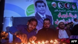 FILE - Members of Shiite Ulema Council, a Shiite Muslim religious-political organization, light candles for Arshad Sharif, a Pakistani journalist killed in Kenya, during a ceremony in Karachi, Oct. 29, 2022.