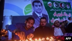 Members of Shiite Ulema Council, a Shiite Muslim religious-political organization, light candles for Arshad Sharif, a Pakistani journalist killed in Kenya, during a ceremony in Karachi, Oct. 29, 2022.