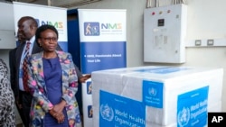 FILE - Uganda's Minister of Health Jane Ruth Aceng receives boxes containing one of three candidate vaccines against the Sudan strain of the Ebola virus, in Entebbe, Uganda, Dec. 8, 2022. 