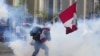 Un simpatizante del destituido presidente Pedro Castillo devuelve un contenedor de gas lacrimógeno en dirección a la policía, el 12 de diciembre de 2022, en Lima, Perú