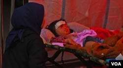 Ayu Rahayu sedang menemani anaknya, Nur Alika (kanan) yang mengalami lula di kepala dan pelipis matanya dirawat di RSUD Sayang pasca gempa berkekuatan 5.6 magnitudo mengguncang Cianjur pada Senin (21/11) siang. (VOA/Indra Yoga)