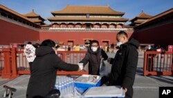 Para petugas mengirimkan makanan bagi para pekerja di area Forbidden City di Beijing, pada 14 Desember 2022. (Foto: AP/Ng Han Guan)