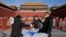 Para petugas mengirimkan makanan bagi para pekerja di area Forbidden City di Beijing, pada 14 Desember 2022. (Foto: AP/Ng Han Guan)