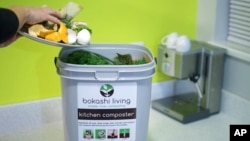 This image provided by Bokashi Living shows kitchen scraps being added to a bokashi composting bucket. (bokashiliving.com via AP)