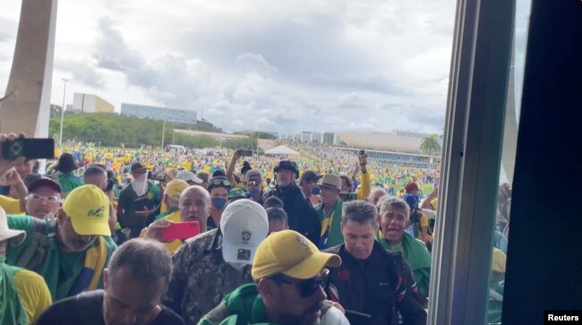 Supporters ofÊBrazil's former President Jair Bolsonaro walk through a flooded office during aÊprotest against President Luiz Inacio Lula da Silva in Brasilia,ÊBrazil January 8, 2023 in this screen grab obtained from a social media video. (George Marques/via REUTERS)