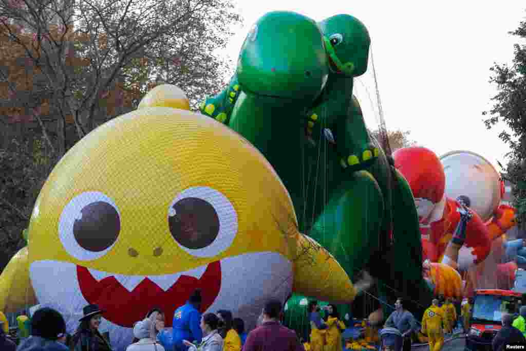 Muchas personas se reúnen un día antes para ver los globos que serán parte del desfile.