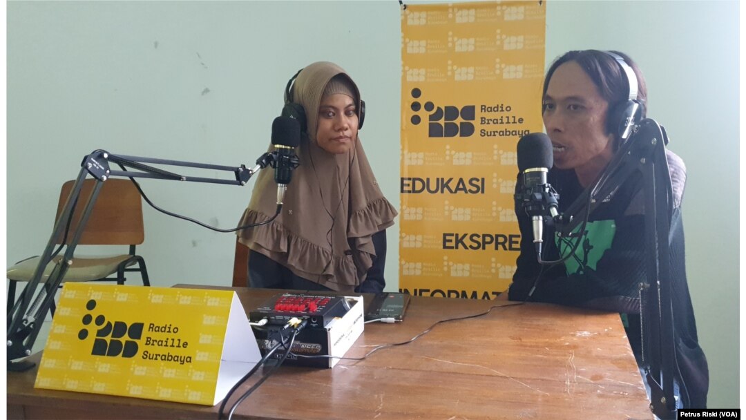 Eben Haezer, Ketua AJI Surabaya (kanan) sedang berbincang mengenai Hari Disabilitas Internasional. (Foto: VOA/Petrus Riski)