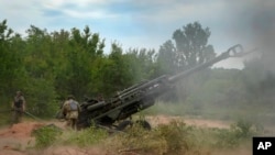 FILE - Ukrainian soldiers fire at Russian positions from a U.S.-supplied M777 howitzer in Ukraine's eastern Donetsk region, June 18, 2022.