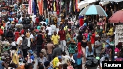 FILE - Shoppers crowd a market in Nigeria's commercial capital of Lagos, Aug. 15, 2019. Eight countries worldwide, including Nigeria, are expected to account for more than half of the global population growth over the next three decades. 