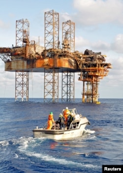 Sebuah tim pengintai meninjau rig pengeboran minyak Montara yang runtuh sebagian dan unit pengeboran lepas pantai bergerak West Atlas di Laut Timor, sekitar 250 kilometer di lepas pantai utara jauh Kimberley negara bagian Australia Barat dalam foto selebaran 22 November 2009 ini. (REUTERS/PTTEP/Handout)