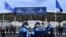 FILE: Members of European Border and Coast Guard Agency Frontex stand outside the new closed migrant camp in the Greek island of Kos on November 27, 2021. 