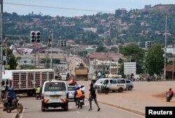 Pengemudi dan pengendara sepeda terlihat di persimpangan lampu lalu lintas di tengah wabah Ebola di Kampala, Uganda, 16 November 2022. (Foto: Reuters)