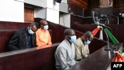 Quatre accusés liés à l'attentat de Grand Bassam Kounta Sidi Mohamed, Cissé Hantao Ag Mohamed, Cissé Mohamed et Barry Hassan siègent dans le box des accusés lors de leur procès au tribunal correctionnel d'Abidjan le 22 décembre 2022.