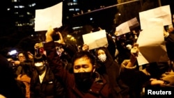 北京民众走上街头举起白纸游行抗议当局严厉的防疫封控措施。（2022年11月27日）