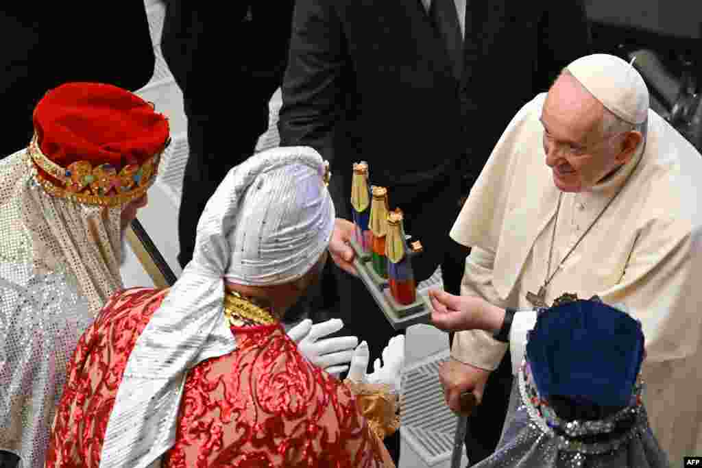 Папата Франциско, десно, ги поздравува верниците облечени како Тројцата мудреци за време на неговата неделна општа аудиенција во салата Павле VI во Ватикан.