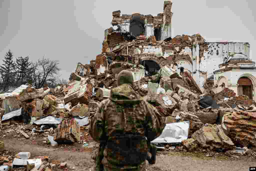 Caesar, 50-year-old, a Russian who joined the Freedom of Russia Legion to fight on the side of Ukraine, stands in front of a destroyed monastery in Dolyna, eastern Ukraine.