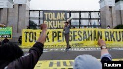 An activist shouts slogans during a protest against Indonesia's potential new criminal code outside the Indonesian Parliament buildings in Jakarta, Indonesia, Dec. 5, 2022. 