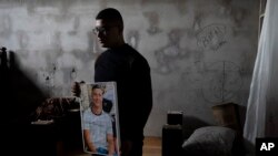 Yousef Mesheh, 15, holds a portrait of his brother, Wael in the bedroom where they were sleeping when Israeli forces stormed into their home at 3.a.m., in the Balata Refugee Camp in the northern West Bank, Jan. 10, 2023.