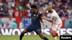 Kingsley Coman (20) regatea a Aissa Laidouni (14) durante el partido de hoy en Qatar. (Crédito: Yukihito Taguchi-USA TODAY Sports)