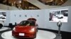 Peluncuran Mobil listrik Tesla Model 3 (kanan) di Bangkok, Thailand, 7 Desember 2022. (Lillian SUWANRUMPHA/AFP)