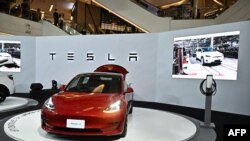 Peluncuran Mobil listrik Tesla Model 3 (kanan) di Bangkok, Thailand, 7 Desember 2022. (Lillian SUWANRUMPHA/AFP)