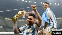 Messi celebra la victoria en la final con el trofeo de la Copa del Mundo, con Lautaro Martínez detrás el 18 de diciembre de 2022.