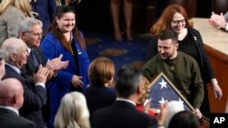 Ukrainian President Volodymyr Zelenskyy holds an American flag that was gifted to him by House Speaker Nancy Pelosi of Calif., as he leaves after addressing a joint meeting of Congress on Capitol Hill in Washington, Dec. 21, 2022.