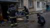 Lilia Kristenko, 38, cries as city responders collect the dead body of her mother, Natalia Kristenko, in Kherson, southern Ukraine, Nov. 25, 2022.