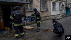 Lilia Kristenko, 38, cries as city responders collect the dead body of her mother, Natalia Kristenko, in Kherson, southern Ukraine, Nov. 25, 2022.