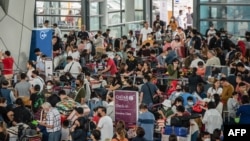 Passengers wait for information about their flights at terminal 3 of Ninoy Aquino International Airport in Pasay, Metro Manila, Philippines, Jan. 1, 2023.