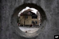 A tax office building that was heavily damaged by Russian shelling, is seen through the fence, in Kyiv, Ukraine, Wednesday, Dec. 14, 2022. (AP Photo/Evgeniy Maloletka)