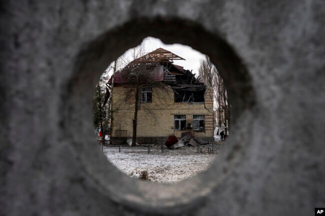 A tax office building that was heavily damaged by Russian shelling, is seen through the fence, in Kyiv, Ukraine, Wednesday, Dec. 14, 2022. (AP Photo/Evgeniy Maloletka)