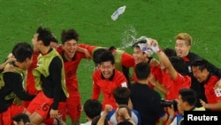 South Korea's Son Heung-min, center, and teammates celebrate after defeating Portugal and qualifying for the knockout stage of the World Cup on Dec. 2, 2022.