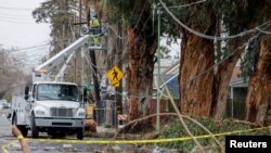 Wafanyakazi wa kituo cha umeme cha Wilaya ya Sacramento, California wanatengeneza waya za umeme zilizoanguka kufuatia dhoruba, Januari 9, 2023. Picha ya Reuters