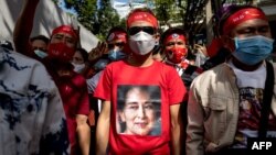 Seorang pengunjuk rasa mengenakan kaus bergambar pemimpin Myanmar Aung San Suu Kyi yang ditahan selama demonstrasi di luar Kedutaan Besar Myanmar di Bangkok pada 19 Desember 2022. (Foto: AFP)