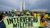 Manifestantes pró-Bolsonaro, seguram uma faixa que diz "Intervenção Militar" ao assaltarem o edifício do Congresso Nacional em Brasília, 8 Janeiro 2023