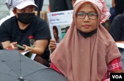 Sri Siti Marni (kanan), salah satu PRT yang mengikuti aksi damai mendesak pengesahan segera RUU PPRT, 21 Desember 2022. Ani mengalami penyiksaan oleh majikannya selama 9 tahun bekerja menjadi PRT. (Foto: VOA/Indra Yoga)