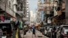 A man pushes a trolley across a street in the Kowloon district of Hong Kong on Nov. 22, 2022. 