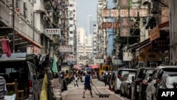 A man pushes a trolley across a street in the Kowloon district of Hong Kong on Nov. 22, 2022. 