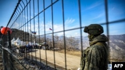 Seorang anggota pasukan perdamaian Rusia tampak menjaga area koridor Lachin yang berada di wilayah sengketa Armenia-Azerbaijan Nagorno-Karabakh pada 27 Desember 2022. (Foto: AFP/Tofik Babayev)