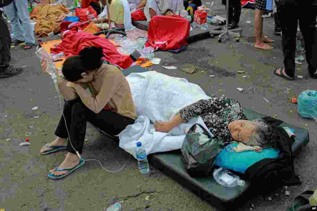 Earthquake survivors are treated outside of a hospital in Cianjur, West Java, Indonesia.&nbsp;A powerful earthquake has toppled buildings on the country&#39;s densely populated main island, killing at least 162 people and injuring hundreds.&nbsp;