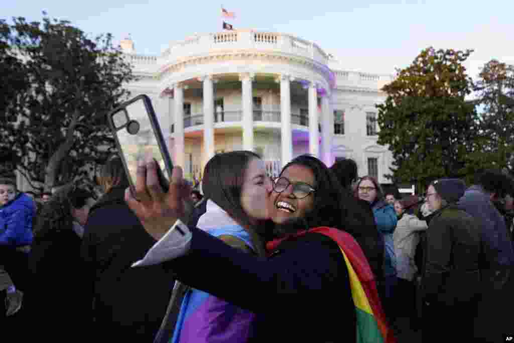 Апарна Шривастава, десно, се фотографира додека нејзината партнерка Шелби Титер ја бакнува, откако претседателот Џо Бајден го потпиша Законот за почитување на бракот, на јужниот тревник на Белата куќа во Вашингтон.