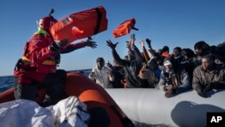 ARHIVA - Migranti iz Afrike na gumenom čamcu u Sredozemnom moru, dobijaju pojaseve za spasavanje od pripadnika španske NVO "Aita Mari", 28. januara 2022. (Foto: AP/ Pau de la Calle)