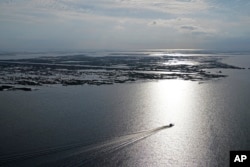 A boat travels past fragmented marsh in Plaquemines Parish, Louisiana, Nov. 3, 2021.